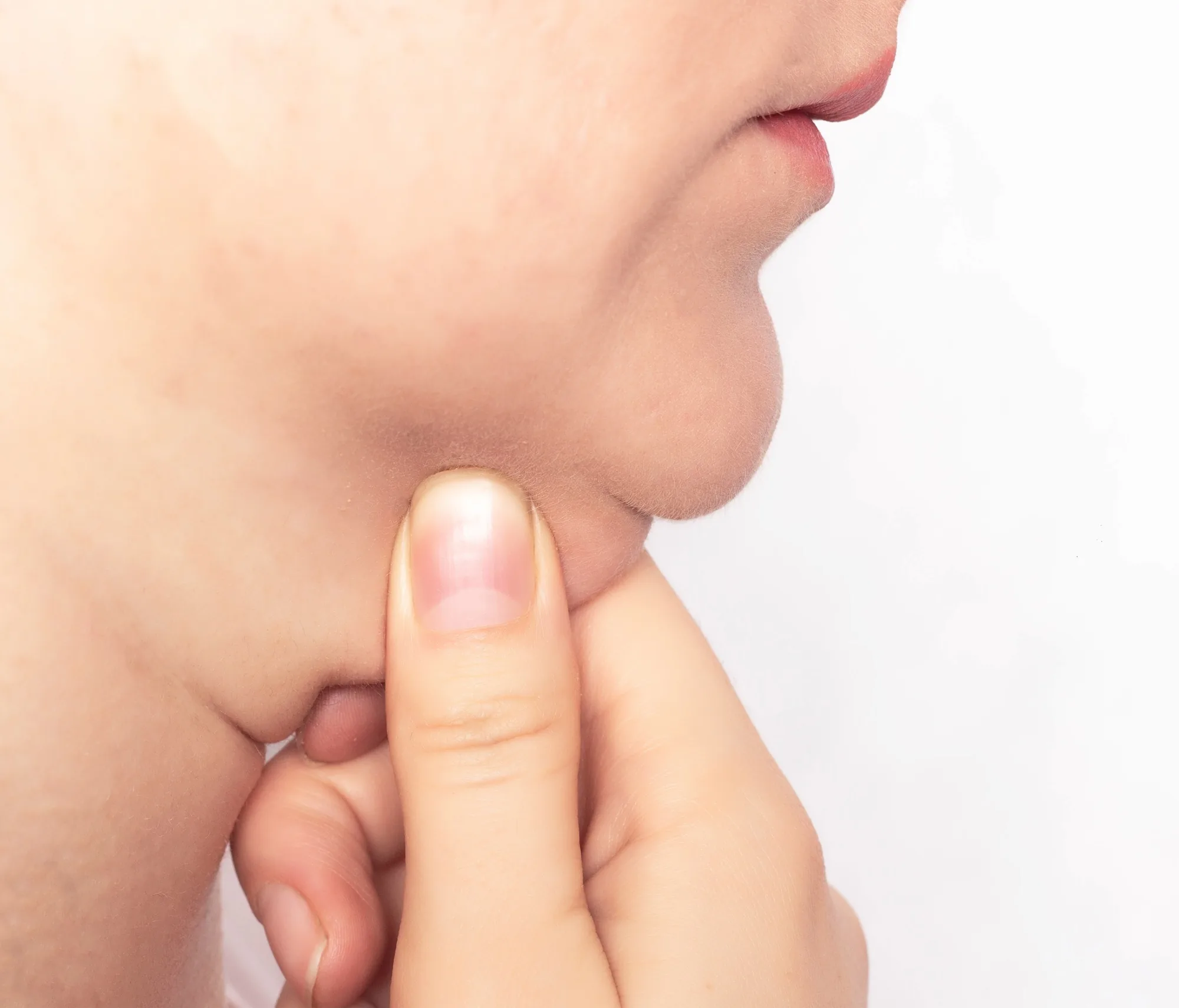 Close-up of a person pinching skin underneath their chin to check submental fat